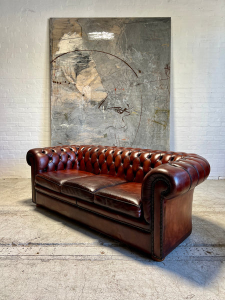 An Amazing Matching Pair of MidC Hand Dyed Leather Chesterfield Sofas Finished in A Cognac Wine