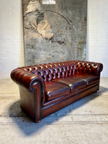 An Amazing Matching Pair of MidC Hand Dyed Leather Chesterfield Sofas Finished in A Cognac Wine