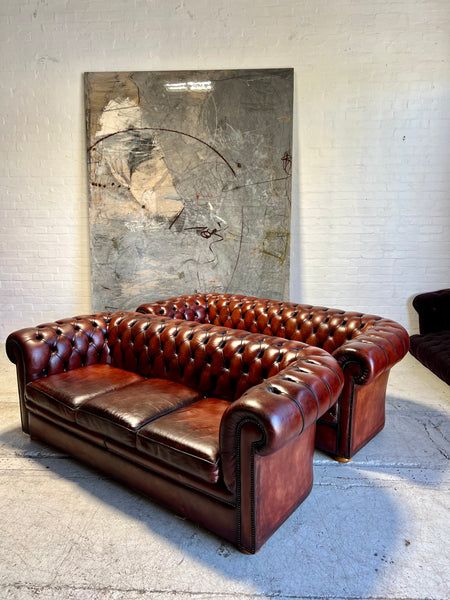 An Amazing Matching Pair of MidC Hand Dyed Leather Chesterfield Sofas Finished in A Cognac Wine